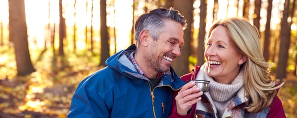Couple in the woods having a warm drink