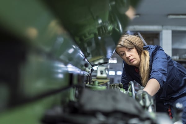Person operating an industrial machine in a workshop.