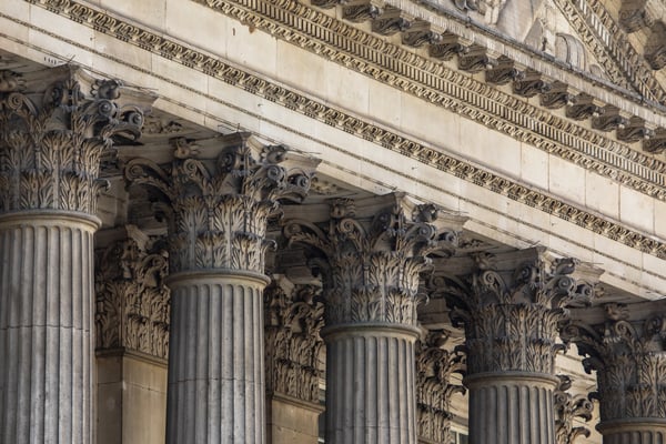 Close-up view of ornate Corinthian columns on a classical stone building façade.