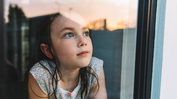 Young girl gazing out of a window