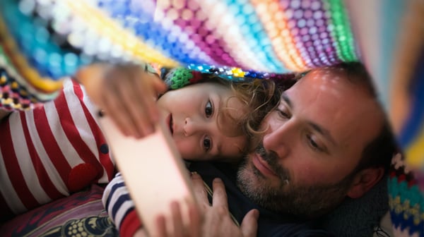 Man and child under blanket